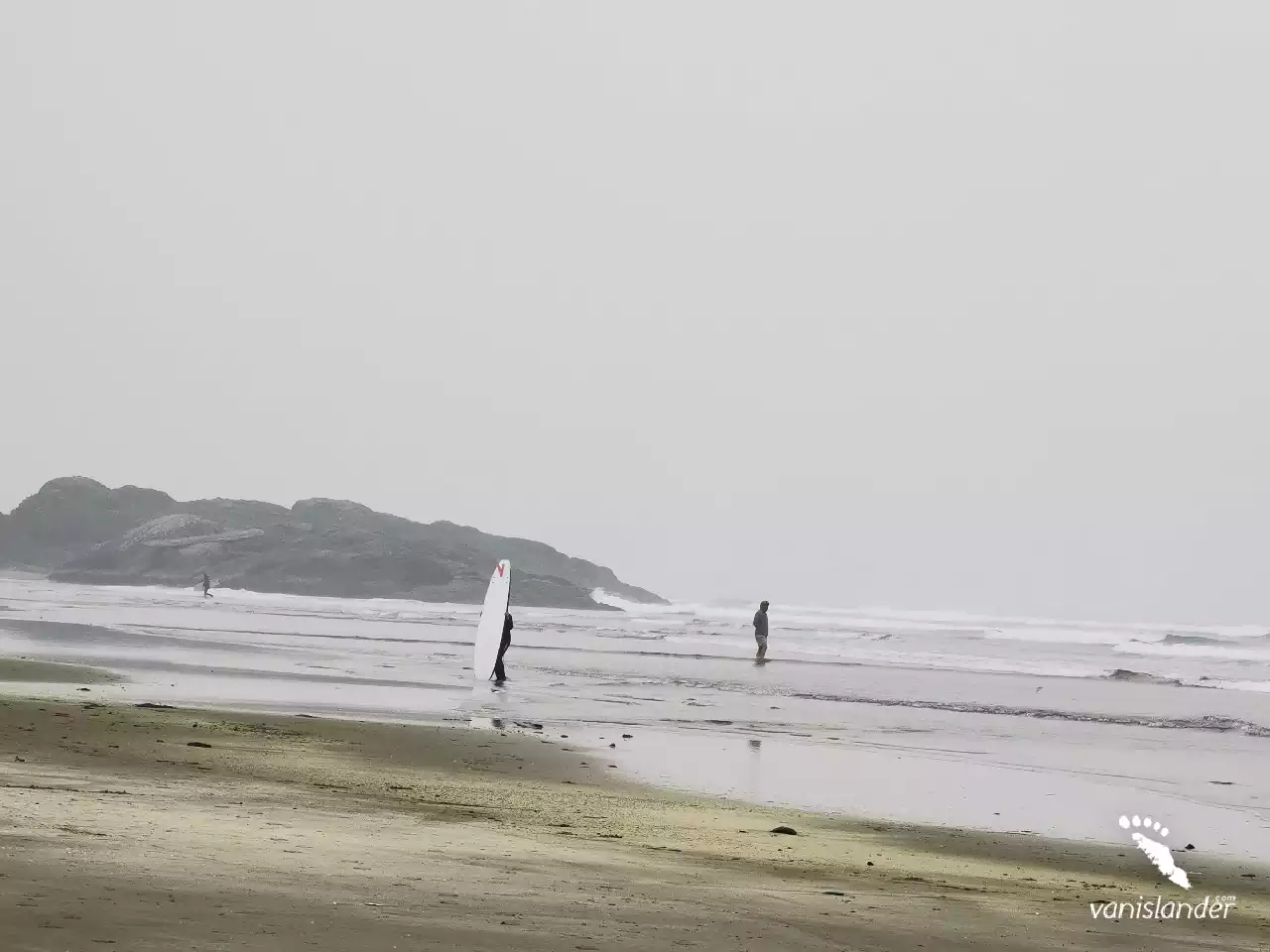 Surfers walking by the ocean on Long Beach,  Vancouver Island